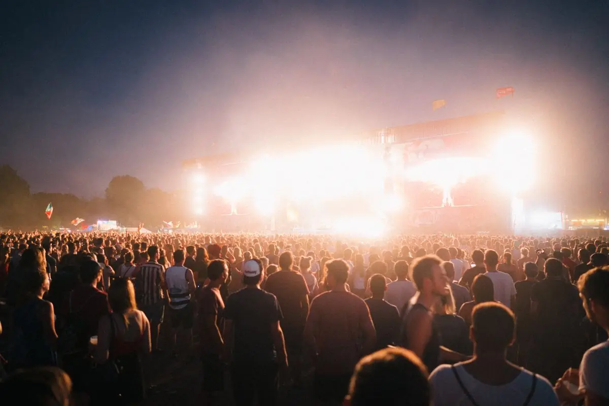 Large festival crowd in front of a lit stage