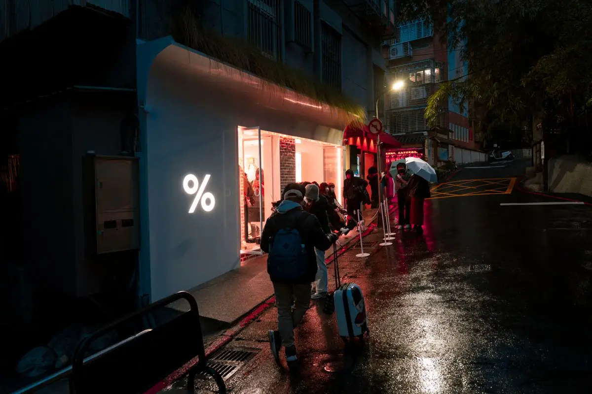 People waiting in line outside a store in the rain